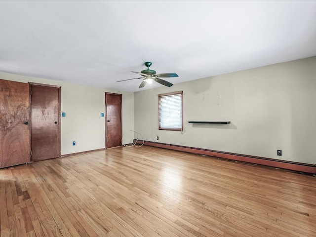 empty room with baseboards, ceiling fan, a baseboard radiator, and light wood-style floors