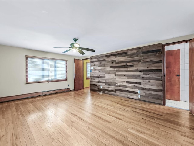 unfurnished living room with hardwood / wood-style flooring, ceiling fan, and baseboard heating