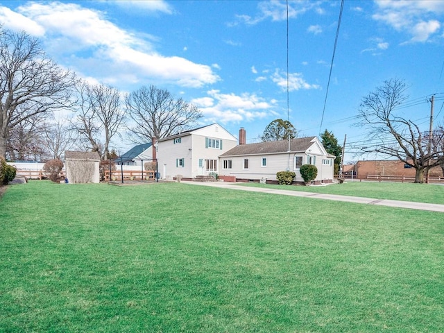 view of yard featuring an outbuilding, a storage shed, and fence