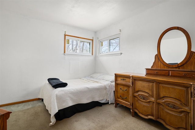 bedroom featuring baseboards and light colored carpet