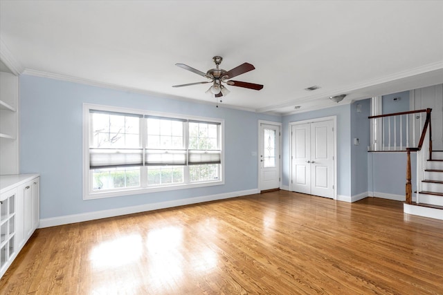 unfurnished living room with light wood-type flooring, baseboards, stairs, and visible vents