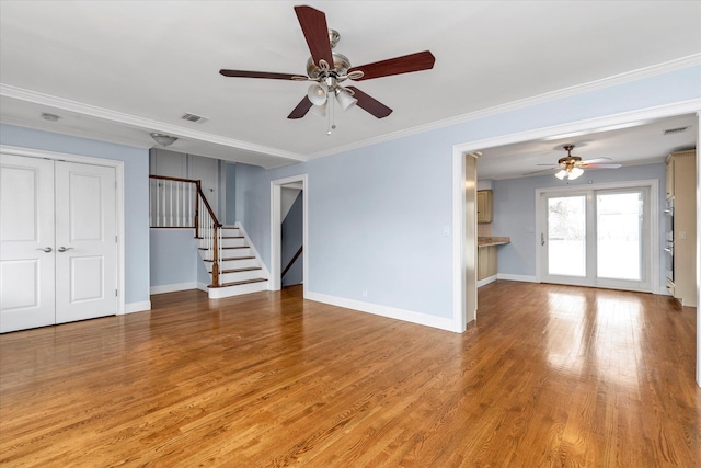 spare room with stairs, light wood-style flooring, ornamental molding, and visible vents