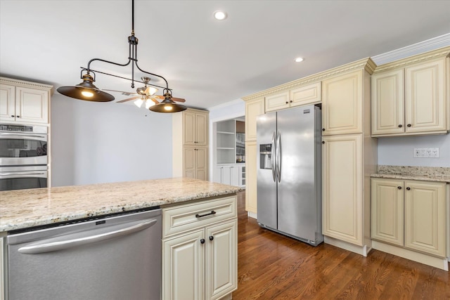 kitchen featuring dark wood-style floors, light stone counters, cream cabinets, stainless steel appliances, and recessed lighting