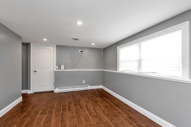 interior space featuring dark wood-style flooring, visible vents, baseboards, and baseboard heating