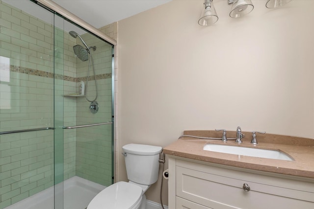 full bath with tiled shower, vanity, and toilet