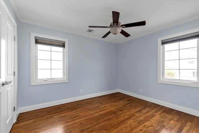 spare room with dark wood-style floors, baseboards, visible vents, and crown molding