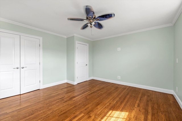 unfurnished bedroom with ornamental molding, a ceiling fan, baseboards, and wood finished floors