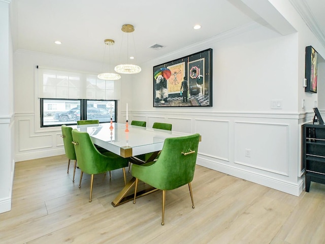 dining space with ornamental molding, visible vents, and light wood-style flooring