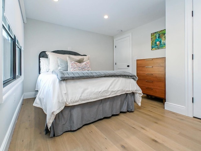 bedroom featuring baseboards, wood finished floors, and recessed lighting