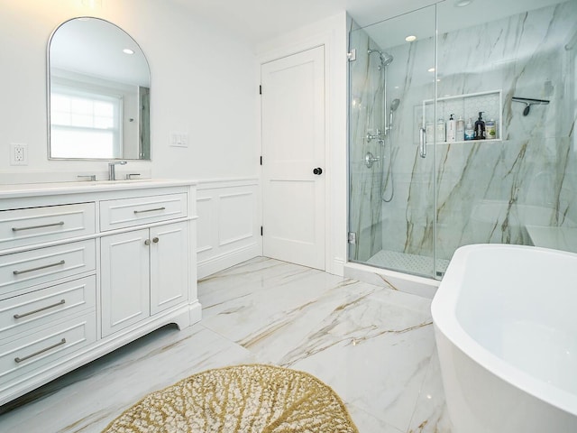 full bathroom featuring marble finish floor, a wainscoted wall, a marble finish shower, a freestanding bath, and vanity