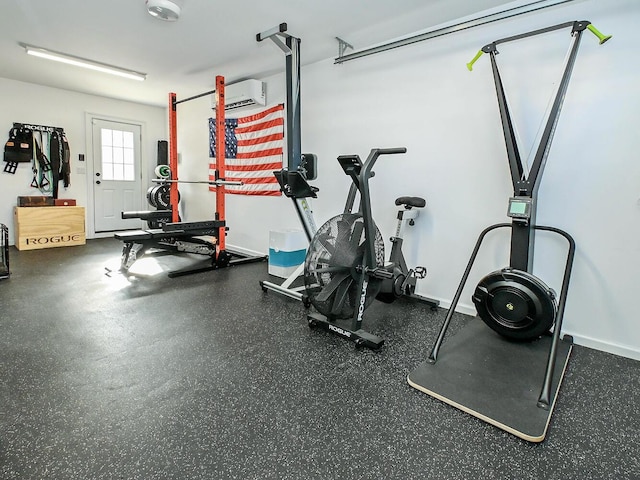 exercise area featuring baseboards and an AC wall unit