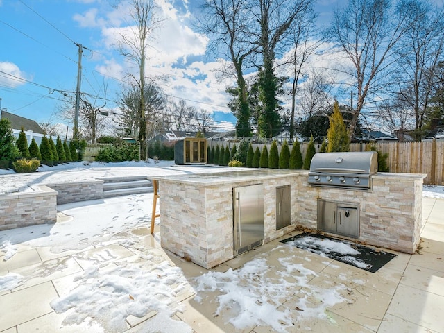 view of patio / terrace with fence, grilling area, and exterior kitchen