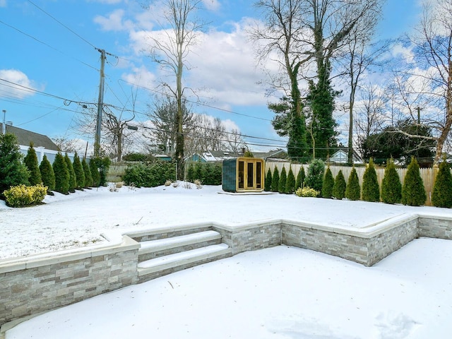 yard covered in snow featuring fence