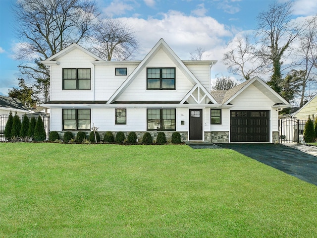 modern inspired farmhouse featuring a garage, fence, driveway, stone siding, and a front yard