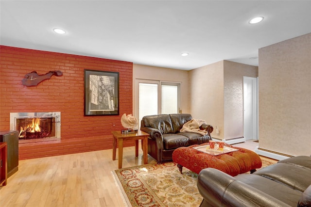 living room with baseboard heating, a brick fireplace, light wood-style flooring, and recessed lighting