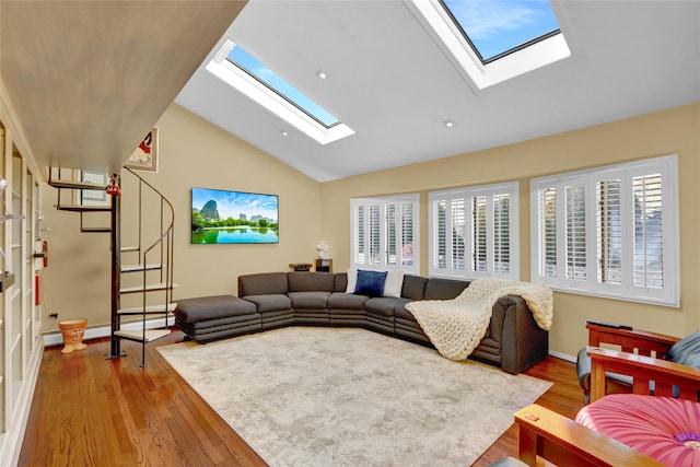 living room featuring lofted ceiling with skylight, wood finished floors, and baseboards