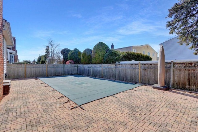 view of swimming pool featuring a fenced backyard and a patio