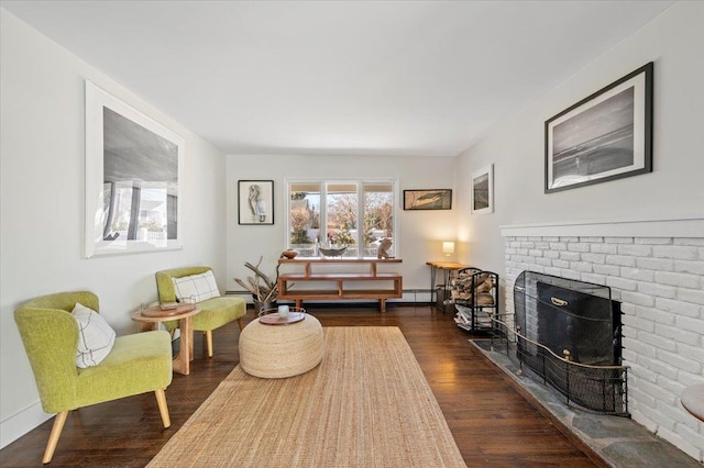 sitting room featuring a fireplace and dark wood finished floors