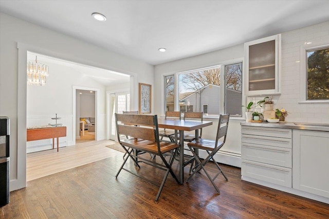 dining room featuring dark wood-style floors, a baseboard heating unit, an inviting chandelier, and recessed lighting