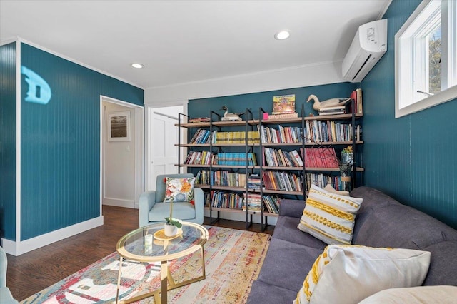 living area with recessed lighting, wood finished floors, baseboards, an AC wall unit, and crown molding