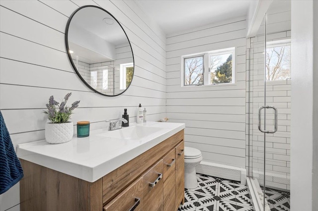 full bath with a baseboard radiator, toilet, wood walls, vanity, and a shower stall