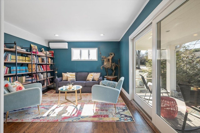 living area featuring a wall unit AC and wood finished floors