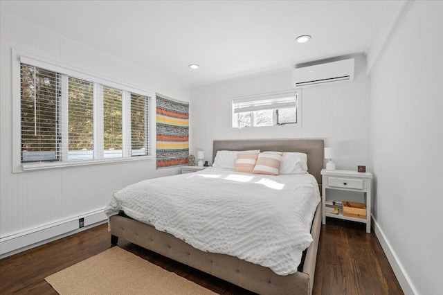 bedroom with a wall unit AC, multiple windows, and wood finished floors