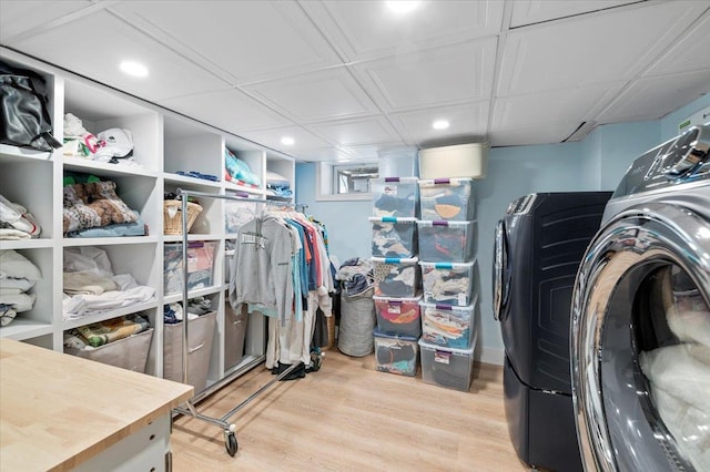 walk in closet featuring light wood finished floors and washing machine and clothes dryer