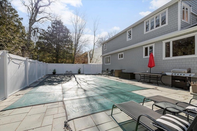 view of pool with a patio area, a fenced backyard, a grill, and a fenced in pool