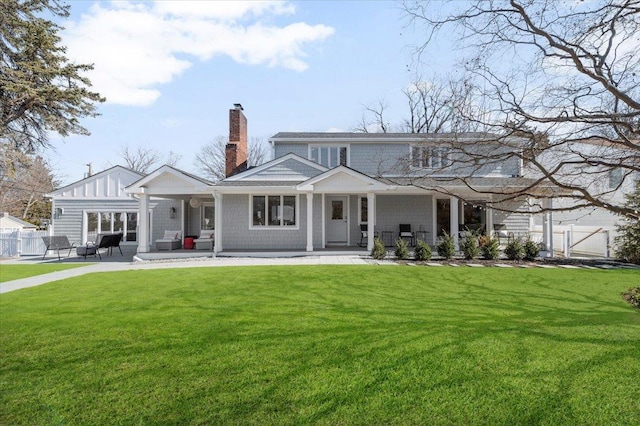 back of property featuring a yard, a patio area, fence, and a chimney