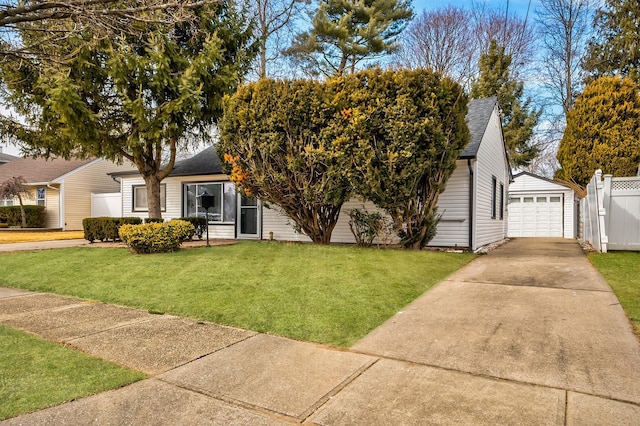 view of front of property featuring roof with shingles, a front lawn, and an outdoor structure