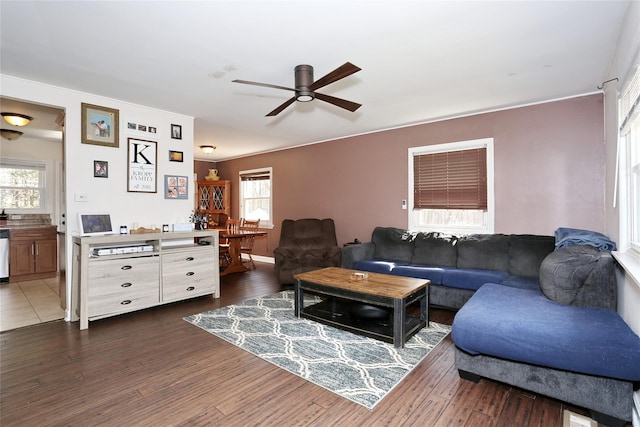 living area with a ceiling fan and dark wood-style flooring