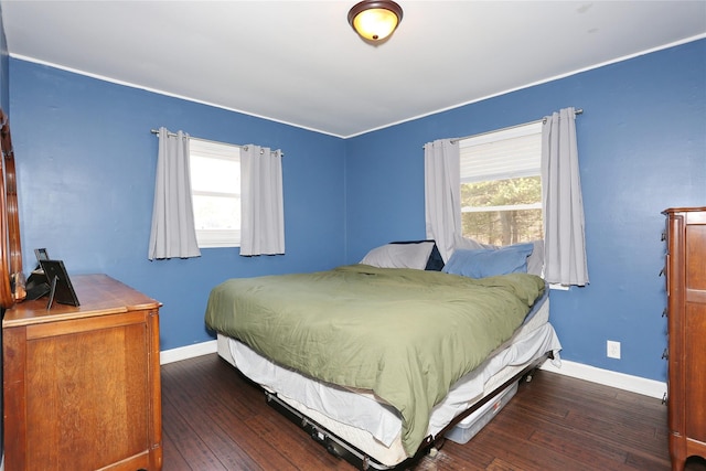 bedroom featuring dark wood-style floors, multiple windows, and baseboards