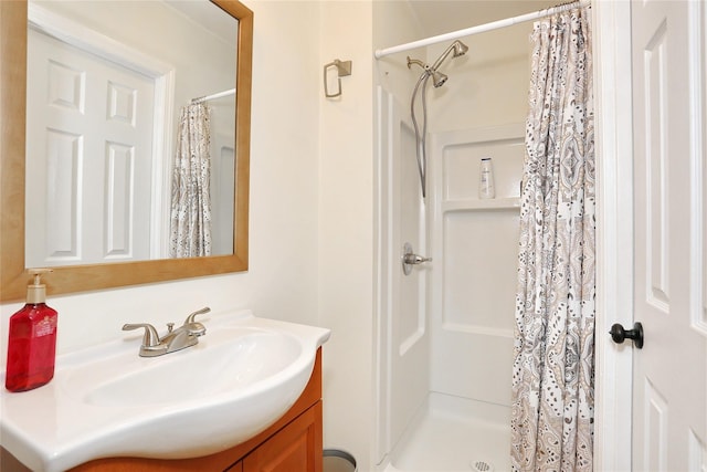 bathroom with a shower stall and vanity