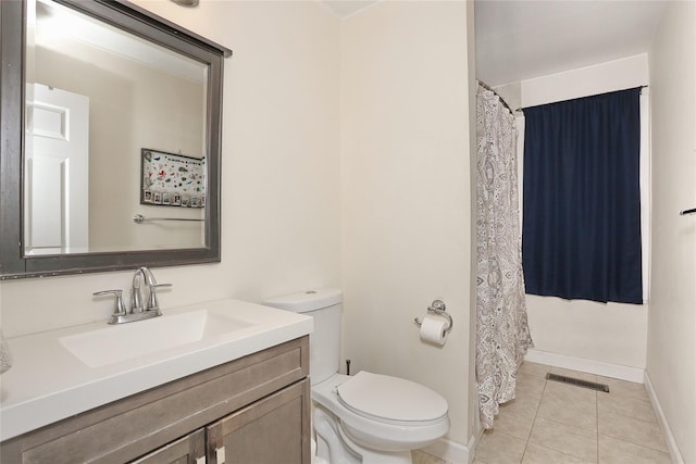 bathroom featuring toilet, vanity, baseboards, visible vents, and tile patterned floors