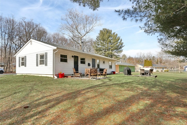 rear view of house featuring entry steps, a yard, and a patio