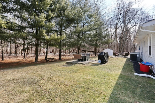 view of yard with cooling unit and a patio