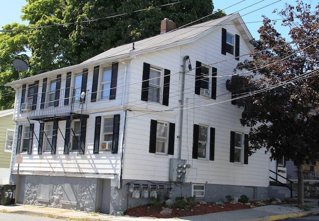 view of side of property featuring a chimney and cooling unit