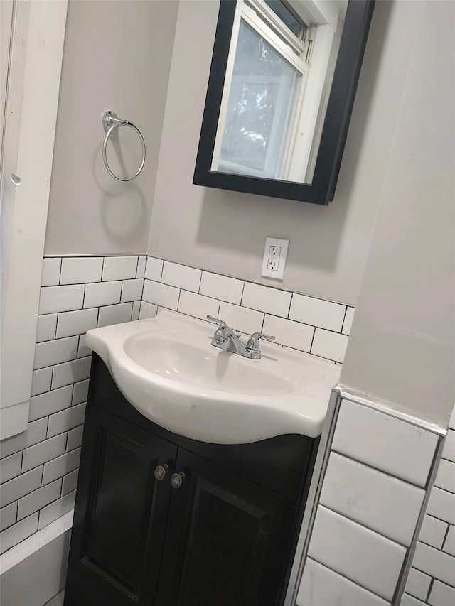 bathroom featuring a wainscoted wall, tile walls, and vanity