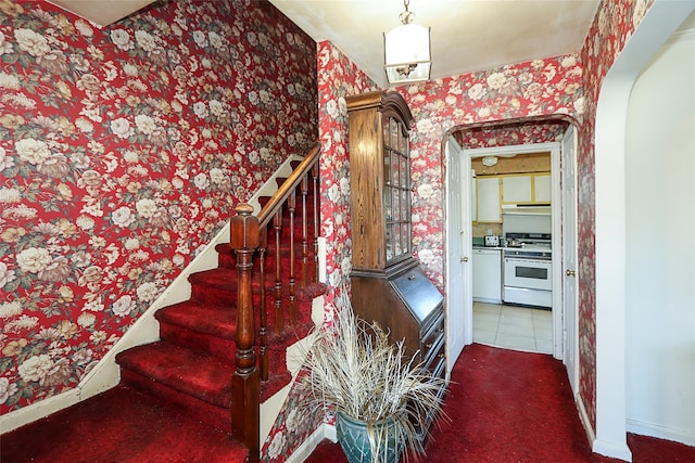 stairs featuring tile patterned flooring, carpet flooring, baseboards, and wallpapered walls