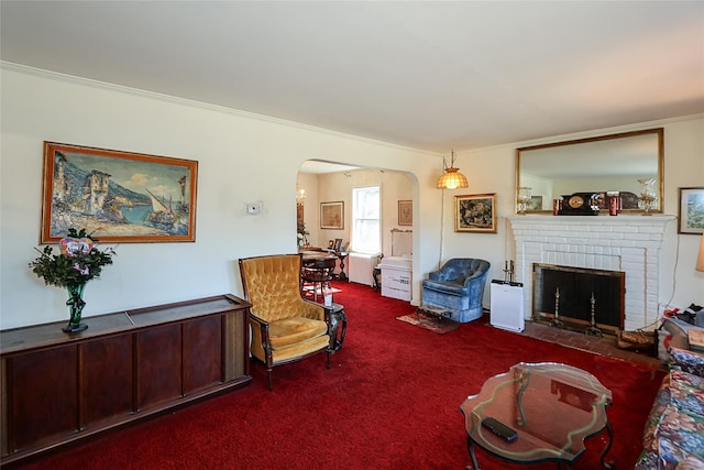 living area featuring carpet, a fireplace, arched walkways, and ornamental molding