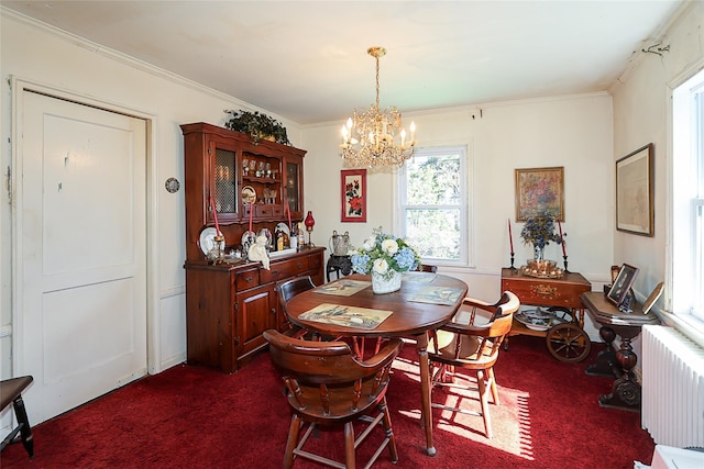 dining room with radiator, a notable chandelier, dark colored carpet, and crown molding