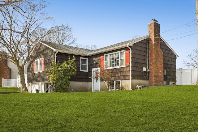 exterior space with fence, a chimney, and a front lawn