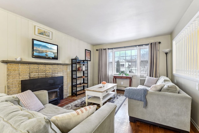 living room with a fireplace and dark wood-style flooring