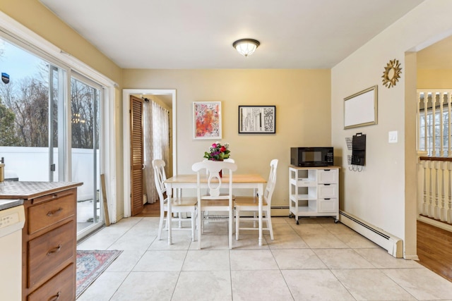 dining space featuring light tile patterned floors, baseboard heating, and plenty of natural light