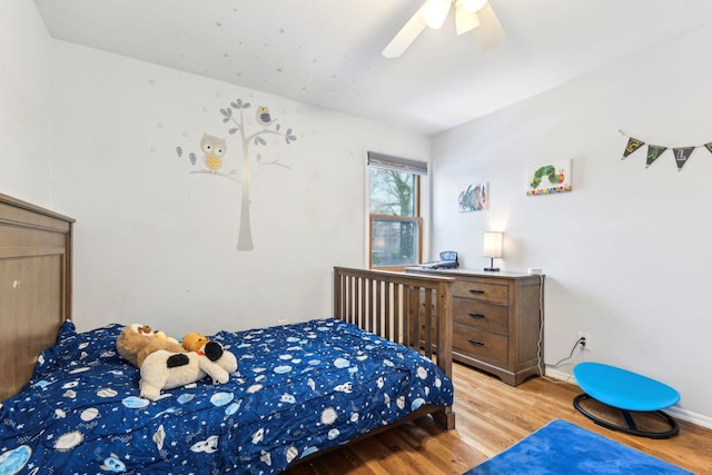 bedroom featuring ceiling fan, light wood-style flooring, and baseboards