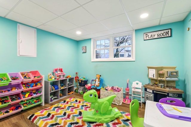 playroom with wood finished floors, a paneled ceiling, and recessed lighting