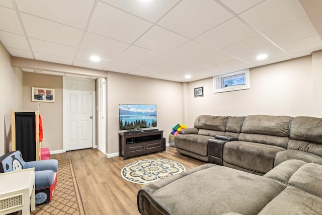 living room with light wood-style floors, baseboards, a drop ceiling, and recessed lighting