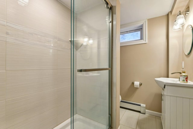 bathroom featuring a baseboard heating unit, a stall shower, vanity, and baseboards