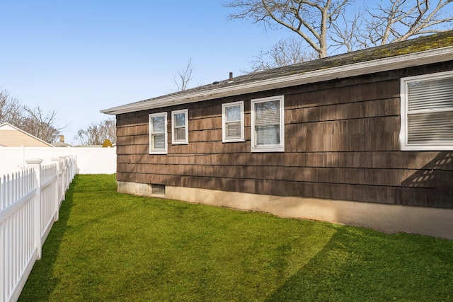 view of property exterior with a lawn and fence